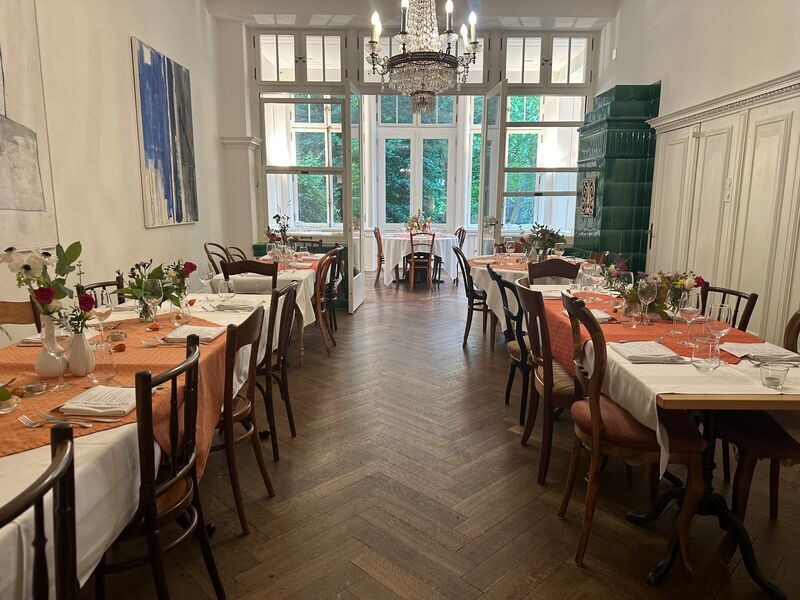 Bistrot-Saal mit Kronleuchter und festlich gedeckten Tischen
